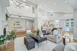 Living room featuring high vaulted ceiling, light hardwood / wood-style flooring, and ceiling fan