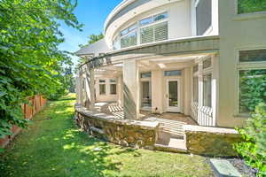 Back of property with a lawn and a patio area