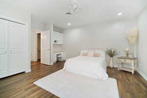 Bedroom with ceiling fan, dark wood-type flooring, and a closet