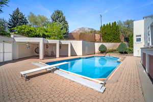 View of swimming pool with a patio, a diving board, and a mountain view