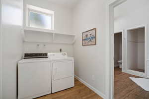 Laundry area featuring independent washer and dryer and light hardwood / wood-style floors