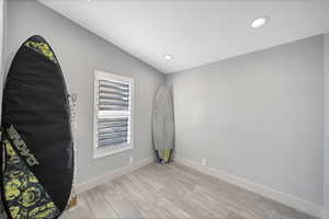 Unfurnished room with vaulted ceiling and light hardwood / wood-style floors