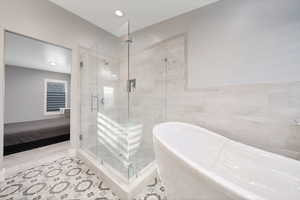 Bathroom with tile walls, plus walk in shower, and tile patterned flooring