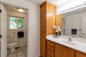 Bathroom with vanity, toilet, and tile patterned flooring