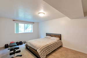 Bedroom featuring a textured ceiling and light carpet