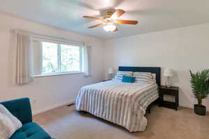 Carpeted bedroom featuring ceiling fan