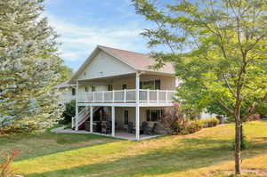 Back of house featuring a lawn and a patio