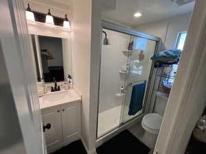 Bathroom with walk in shower, vanity, and toilet