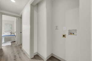 Washroom featuring hookup for a washing machine, light hardwood / wood-style flooring, and hookup for an electric dryer