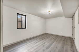 Empty room with hardwood / wood-style flooring and a textured ceiling