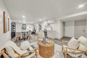 Living room featuring sink, light hardwood / wood-style flooring, and beverage cooler