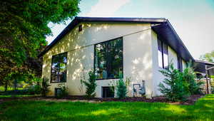 View of side of property with a lawn