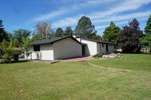 View of home's exterior with a lawn and a patio area