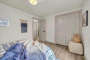 Bedroom featuring light wood-type flooring and a closet