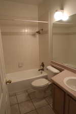 Full bathroom with tile patterned floors, toilet, tiled shower / bath, and vanity