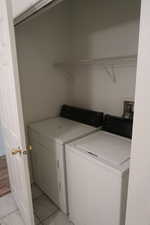 Laundry area featuring washer and dryer and light tile patterned flooring