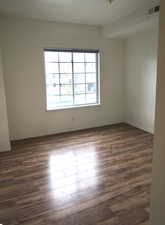 Empty room with dark hardwood / wood-style flooring