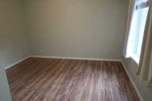 Empty room featuring dark hardwood / wood-style flooring