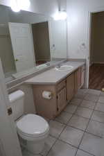 Main Bathroom featuring vanity, tile patterned flooring, and toilet