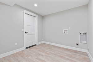 Clothes washing area featuring hookup for an electric dryer, washer hookup, and light hardwood / wood-style floors