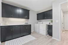 Clothes washing area with independent washer and dryer, light hardwood / wood-style flooring, and cabinets