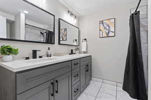 Bathroom with tile patterned floors and double sink vanity