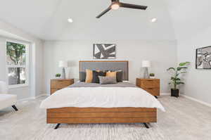 Carpeted bedroom featuring ceiling fan and lofted ceiling