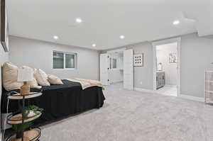 Bedroom with ensuite bathroom and light colored carpet