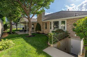 View of front of home featuring a patio area, a garage, and a front yard