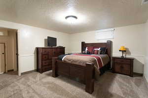 Carpeted bedroom with a textured ceiling