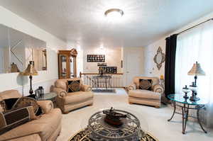 Living room with a textured ceiling and carpet floors