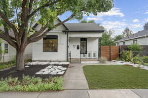 View of front of property with a porch and a front lawn