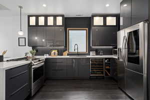 Kitchen featuring backsplash, dark hardwood / wood-style flooring, stainless steel appliances, and sink