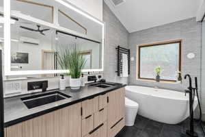 Bathroom with lofted ceiling, a wall mounted AC, tile patterned floors, and dual vanity