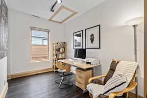 Home office with rail lighting and dark hardwood / wood-style floors