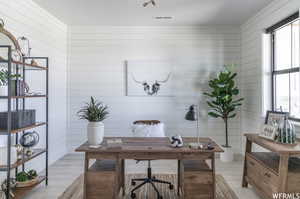 Office featuring light hardwood / wood-style flooring and wooden walls