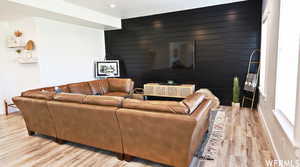 Living room with light hardwood / wood-style flooring and wooden walls