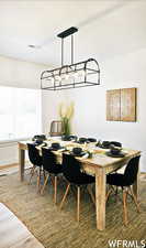 Dining space with wood-type flooring and an inviting chandelier