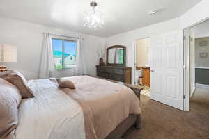 Carpeted bedroom with a chandelier and ensuite bathroom