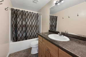 Full bathroom with shower / bathtub combination with curtain, toilet, vanity, and tile patterned flooring