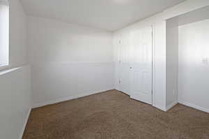 Unfurnished bedroom featuring carpet flooring and a closet