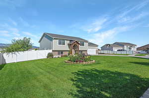 View of front of property featuring a front lawn and a garage