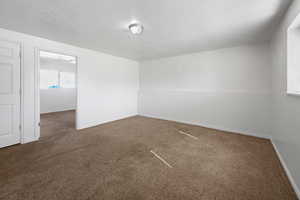 Carpeted empty room with a textured ceiling