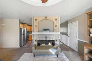 Kitchen with ceiling fan, dark wood-type flooring, stainless steel fridge, range with electric stovetop, and a tile fireplace