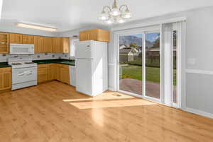 Main floor kitchen with back deck and yard showing through door.