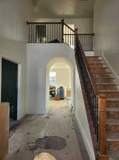 Staircase with a wealth of natural light and a high ceiling