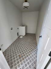 Laundry area with hookup for a washing machine, hookup for an electric dryer, and tile patterned flooring