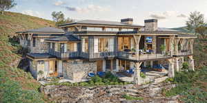 Back of house with a patio area and a balcony