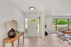 Foyer featuring light wood-type flooring and a healthy amount of sunlight