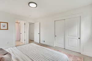 Bedroom with light carpet and a closet